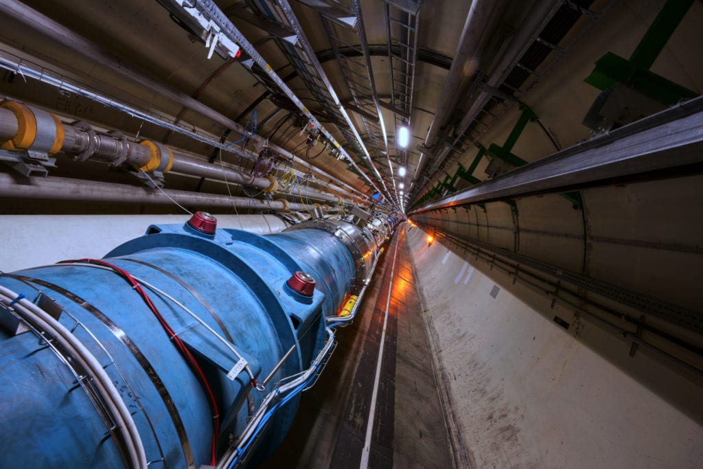 A section of the 27 kilometer (16.6 mile) long circular track of Large Hadron Collider at CERN. Within the blue pipe, particles move at close to the speed of light. Image Credit: CERN